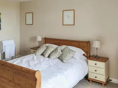 a bedroom with a white bed with pillows on it at Dairy Cottage in Girvan