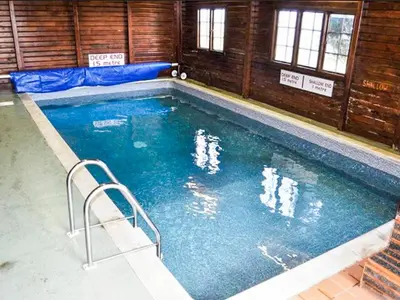 a swimming pool with blue water in a building at The View in Stranraer