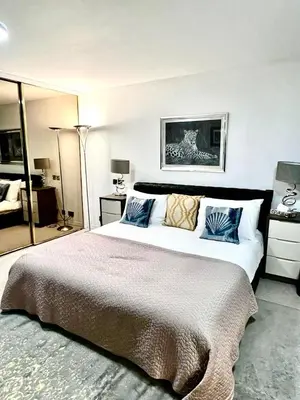 a bedroom with a large bed with blue pillows at Mayfair Piccadilly Apartemnt - 3 in Moffat