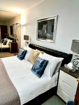 a bedroom with a white bed with blue pillows at Mayfair Piccadilly Apartemnt - 3 in Moffat