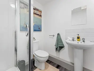 a white bathroom with a toilet and a sink at Modern 2-Bedroom Apartment with Free Parking in Warrington in Moffat