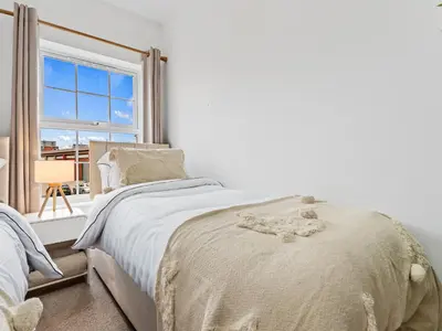 a white bedroom with a bed and a window at Modern 2-Bedroom Apartment with Free Parking in Warrington in Moffat
