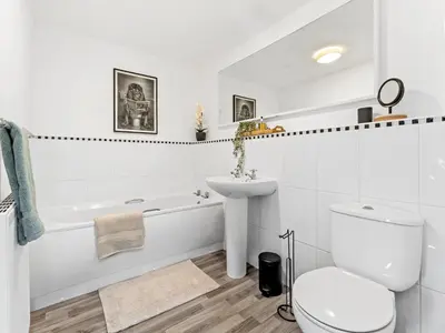 a white bathroom with a toilet and a sink at Modern 2-Bedroom Apartment with Free Parking in Warrington in Moffat