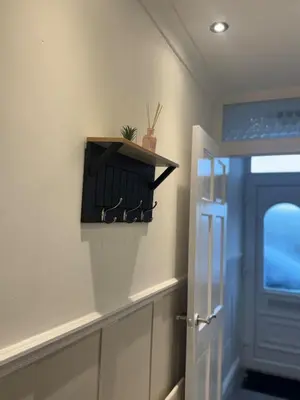 a bathroom with a door and a shelf with glasses at Comfortable Stay with Free Parking in Cleator
