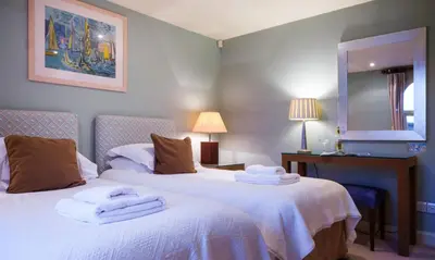 two beds in a hotel room with towels on them at Underscar - Scafell in Applethwaite