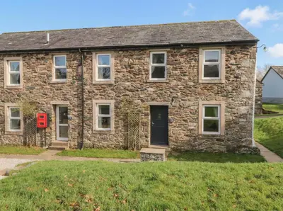 an old stone house with a red mailbox in front of it at 6 Hallin Fell in Watermillock