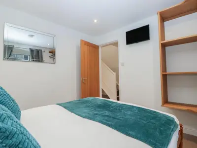 a bedroom with a bed with a green blanket on it at 6 Hallin Fell in Watermillock