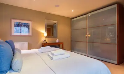 a bedroom with a large white bed with towels on it at Watendlath in Applethwaite