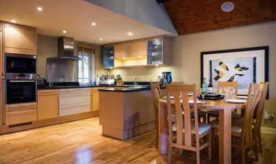 a kitchen with a wooden table and a dining room at Watendlath in Applethwaite