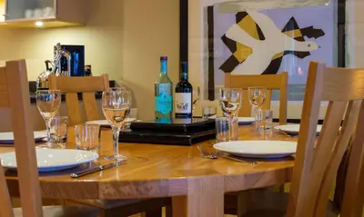 a wooden table with glasses and bottles of wine at Watendlath in Applethwaite