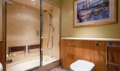 a bathroom with a shower and a tub and a toilet at Watendlath in Applethwaite