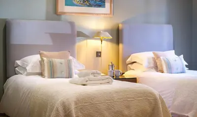 a hotel room with two beds with white sheets at Underscar - Hindscarth in Applethwaite