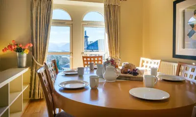 a dining room table with chairs and a large window at Underscar - Hindscarth in Applethwaite