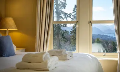 a bedroom with a window with towels on a bed at Underscar - Hindscarth in Applethwaite