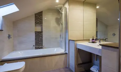 a bathroom with a tub and a toilet and a sink at Catbells in Applethwaite