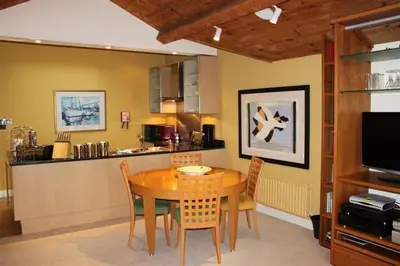 a dining room with a table and a kitchen at Catbells in Applethwaite