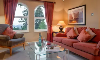 a living room with two couches and a glass table at Brackenburn in Applethwaite