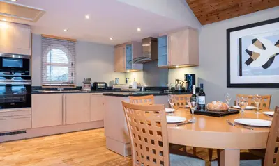 a kitchen with a wooden table and a dining room at Brackenburn in Applethwaite