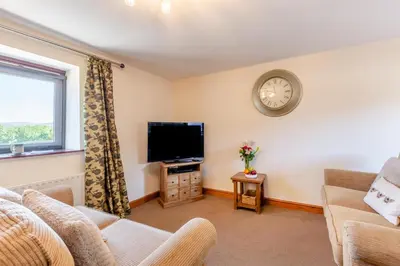 a living room with a tv and a clock on the wall at 2 Bed in Isel oc-o32077 in Sunderland