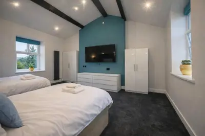 a bedroom with two beds and a flat screen tv at The Croft in Ramsey
