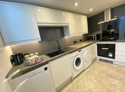 a kitchen with a sink and a washing machine at The Croft in Ramsey