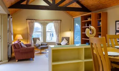 a living room with a table and a dining room at Grisedale in Applethwaite