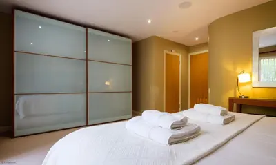a bedroom with a large white bed with towels on it at Underscar - High Spy in Applethwaite