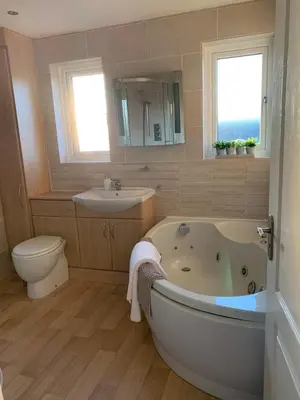 a bathroom with a tub and a toilet and a sink at Fairway House- Stylish refurbished property in Moffat
