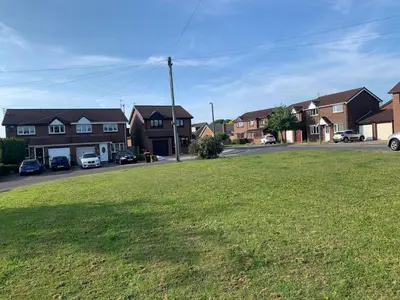 a field of grass in a residential neighborhood with houses at Fairway House- Stylish refurbished property in Moffat