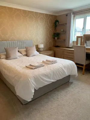 a bedroom with a large bed with two plates on it at Fairway House- Stylish refurbished property in Moffat