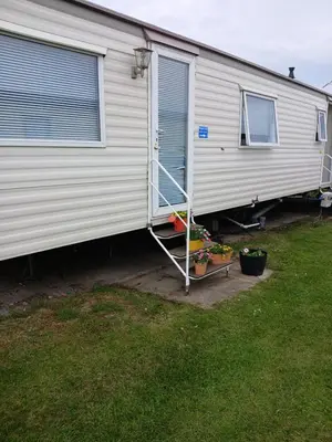 a white trailer with a ladder on the side of it at Mags Home from Home at Southerness in Mainsriddle