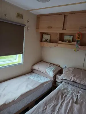 two beds in a small room with a window at Mags Home from Home at Southerness in Mainsriddle