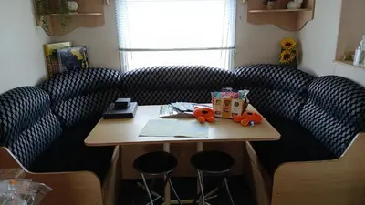 a room with a table with stools and a table with at Mags Home from Home at Southerness in Mainsriddle