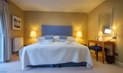 a bedroom with a large white bed and a desk at Underscar - Seatoller in Keswick