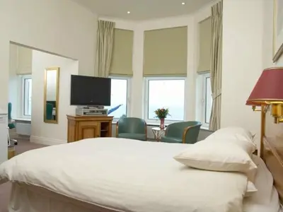 a bedroom with a large bed and a television at Regency Hotel in Douglas