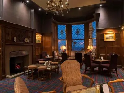 a restaurant with a fireplace and tables and chairs at Regency Hotel in Douglas