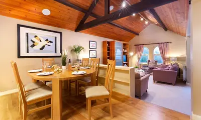a dining room and living room with a table and chairs at Underscar - Whinlatter in Keswick