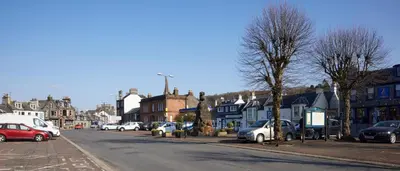 a city street with cars parked on the side of the road at Cosy Cottage in Moffat Town Centre - Pass the Keys in Moffat