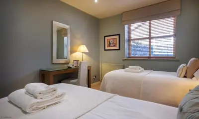 a room with two beds and a desk and a mirror at Underscar - Great Gable in Keswick