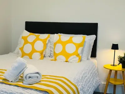 a bedroom with a bed with yellow and white pillows at Vulcan Apartment - 3 Bedrooms - Sleeps 6 in Workington