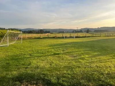 a soccer field with a net in the grass at Rural luxury bungalow in Terreglestown