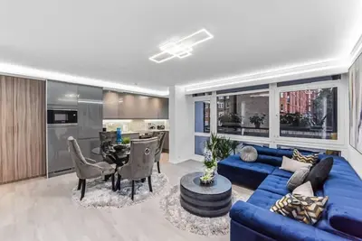 a living room with a blue couch and a table at Luxury 1 Bed near Hyde Park and Marble Arch in Moffat
