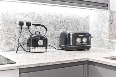 a toaster and toaster on a counter in a kitchen at Luxury 1 Bed near Hyde Park and Marble Arch in Moffat