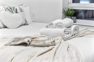 a pile of towels sitting on top of a bed at Luxury 1 Bed near Hyde Park and Marble Arch in Moffat