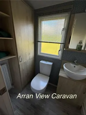 a small bathroom with a toilet and a sink at Arran View Caravan in Ayr