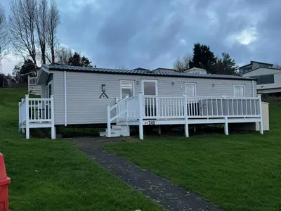 a large white house with a large porch at Arran View Caravan in Ayr