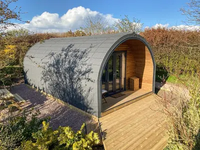 a small circular house with a wooden deck at The Eden Hideaway - Uk1554 in Rockcliffe