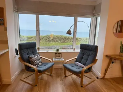 two chairs in a room with a large window at Cliff Cottage Beautifully appointed apartment with world class view in Peel
