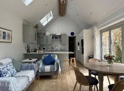 a living room with a couch and a table at Charming Cotswold stone cottage with garden in Moffat
