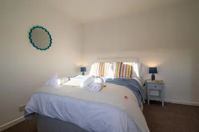 a bedroom with a bed with towels on it at The Bridge- 3 Bedrooms in Coatbridge with Driveway in Moffat